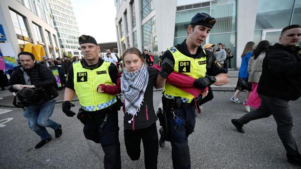 Greta Thunberg trägt einen Palästinenserschal und wird von zwei Polizisten abgeführt