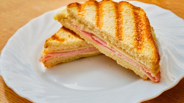 Ein Schinken-Käse-Toast auf einem weißen Teller.