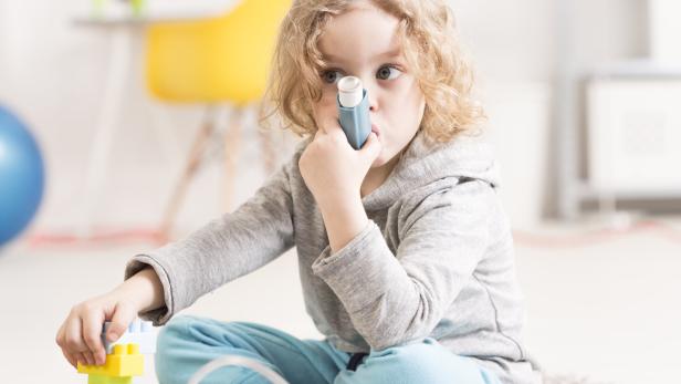 Ein Mädchen mit einem Asthmaspray.