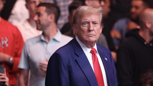 Donald Trump in einem blauen Anzug vor einer Menschenmenge