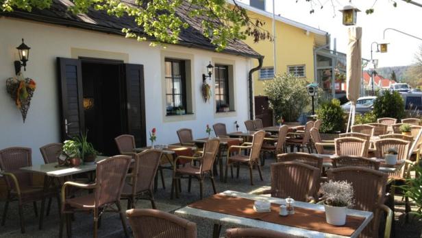 Einladender Außenbereich eines Restaurants mit Tischen und Stühlen.