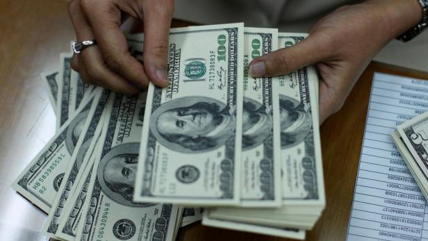 FILE PHOTO: Employee counts U.S. dollar at money changer in Jakarta
