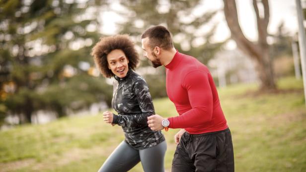 Eine Frau und ein Mann laufen zusammen im Park.