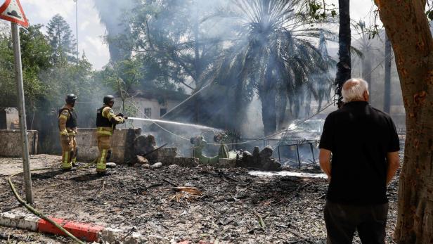 Feuerwehrmänner bekämpfen einen Brand, den eine libanesische Rakete in Kiryat Shmona ausgelöst hat.