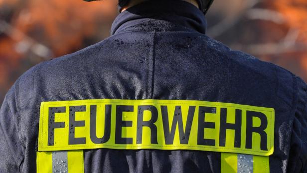 Der Schriftzug „Feuerwehr“ auf dem Rücken eines Feuerwehrmannes.