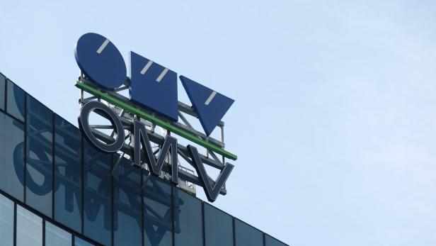 Das OMV-Logo auf einem modernen Bürogebäude unter blauem Himmel.