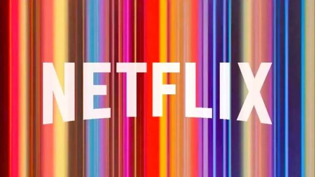 Das Netflix-Logo vor einem bunten, vertikal gestreiften Hintergrund.
