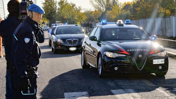 Mehrere Autos der Carabinieri fahren auf einer Straße.