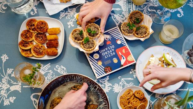 Kleine Häppchen und Getränke mit Händen.