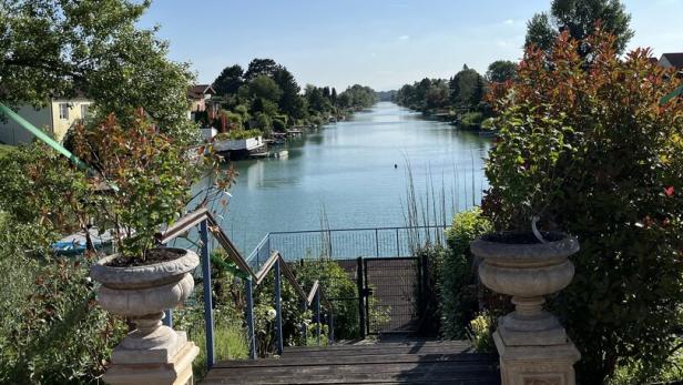 Blick von einer Steintreppe auf einen Kanal an einem sonnigen Tag.