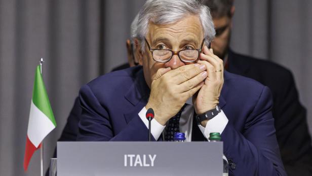 Italienischer Außenminister und Vizepremier Antonio Tajani hält sich die Hand bei einem Telefonat vor den Mund.