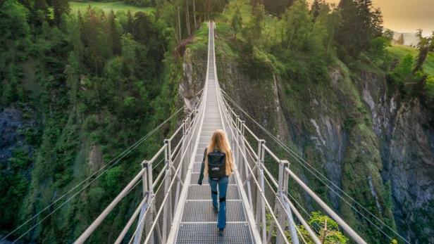Frau geht über eine Hängebrücke über der Inselschlucht Prägraten und Virgen in Osttirol
