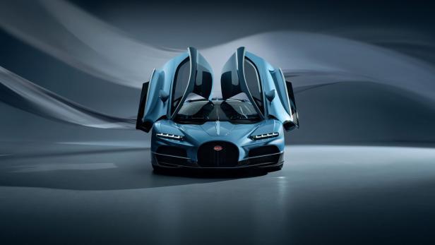 Ein blauer Bugatti mit geöffneten Flügeltüren steht in einem Studio.