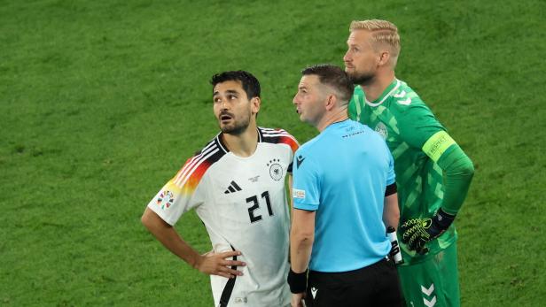 Schiedsrichter Oliver informierte die Kapitäne Gündogan und Schmeichel, die zum Stadiondach blickten