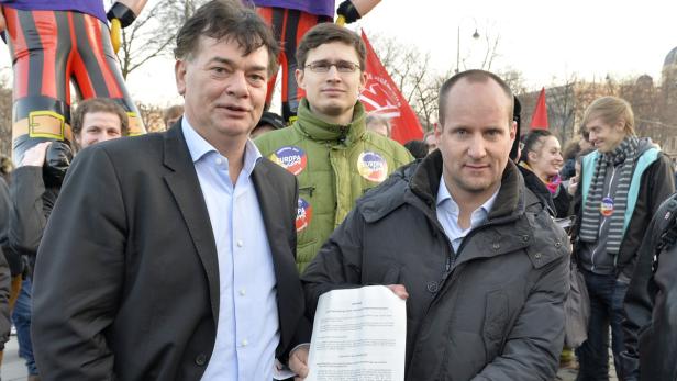 Mehrere Personen posieren bei einer Kundgebung für ein Foto.