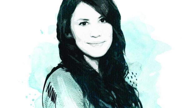 Ein Porträt einer jungen Frau mit langen, dunklen Haaren und einem hellen Lächeln.