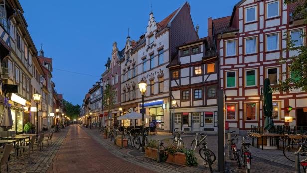 Eine abendliche Szene in einer deutschen Stadt mit Fachwerkhäusern und Fahrrädern am Straßenrand.