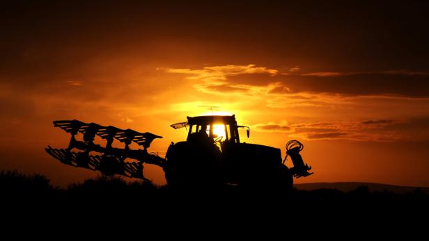 ARCHIV - Ein Landwirt fährt am 13.10.2012 bei Sonnenuntergang mit seinem Trecker samt Pflug über einen Feldweg bei Pattensen (Region Hannover). Die Reform der EU-Agrarpolitik sollte alles ändern: Die Bauern müssten mehr für die Umwelt tun, forderte die EU-Kommission. Foto: Julian Stratenschulte/dpa (zu dpa «Darum geht es bei der Reform der EU-Agrarpolitik» vom 12.03.2013) +++(c) dpa - Bildfunk+++