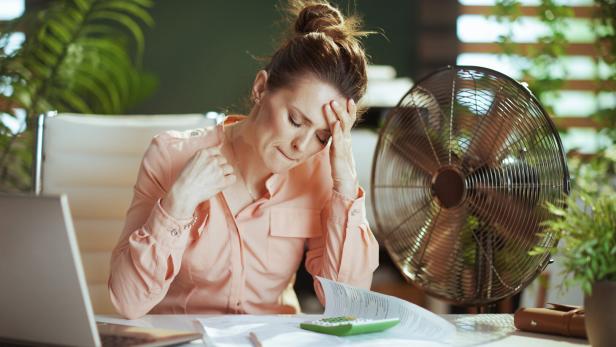 business owner woman in green office suffer from heat