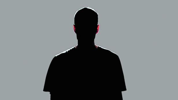 isolated dark male silhouette in the shadow, studio portrait