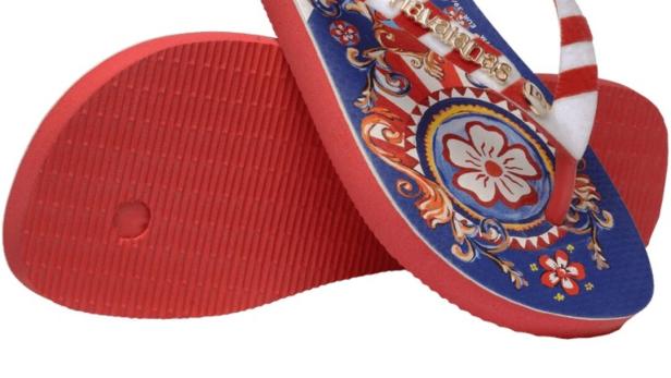 Ein Paar luxuriöse Flip-Flops mit blau-rotem Muster und Blumenornamenten.