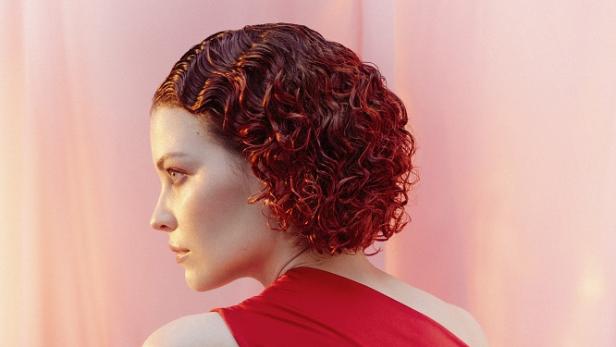 Frau mit roten Haaren posiert für die Kamera.