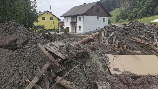 Erde und Schlamm vor Haus nach Unwetter