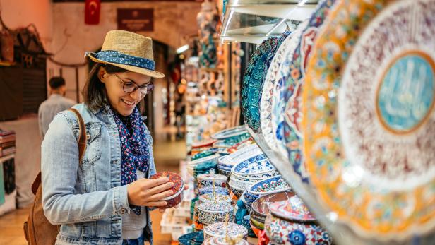 Eine Touristin betrachtet eine Dose in einem Souvenirladen.