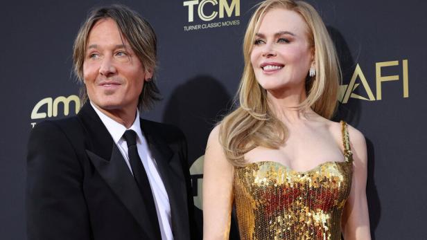 Keith Urban und Nicole Kidman halten Händchen auf dem roten Teppich.
