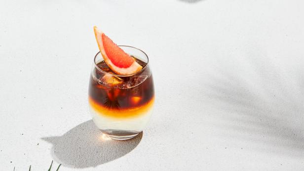 Espresso Tonic mit Orangenscheibe auf weißem Hintergrund