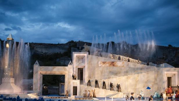 Eine Aufführung von „Oper im Steinbruch“ mit Darstellern auf einer großen Bühne mit Wasserspielen.
