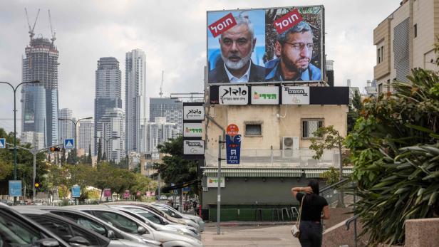 Auf einer Plakatwand in Tel Aviv am 2. August 2024 sind die Porträts von Hamas-Führer Mohammed Deif (r.) und Ismail Haniyeh zu sehen, auf denen in hebräischer Sprache der Slogan "ermordet" zu lesen ist. 