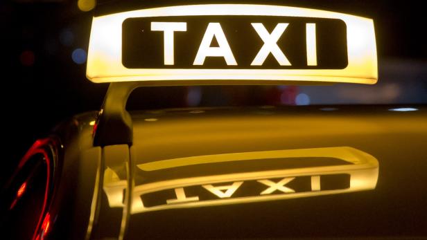 Ein leuchtendes Taxi-Schild bei Nacht.