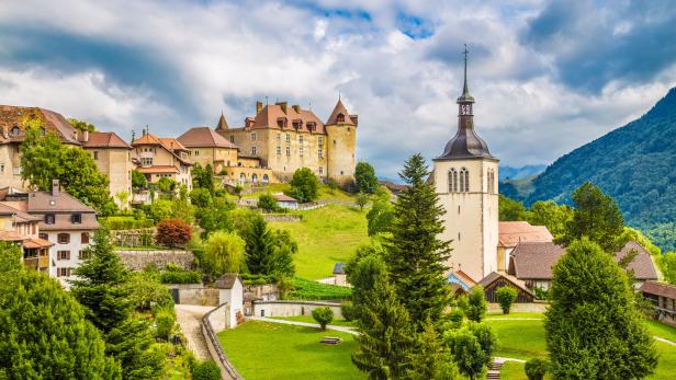 Landschaft und Türme: Blick auf das Schloss und die Pfarrkirche von Gruyères.