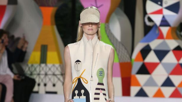 Eine Frau präsentiert ein Kleid mit bunten, abstrakten Mustern von Akris-Chefdesigner Albert Kriemler.