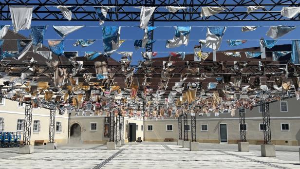 Viele Fähnchen im Wind: Die Installation „Dead, I am Still Paper“ von Mariana Castillo Deball auf dem Domplatz von St. Pölten