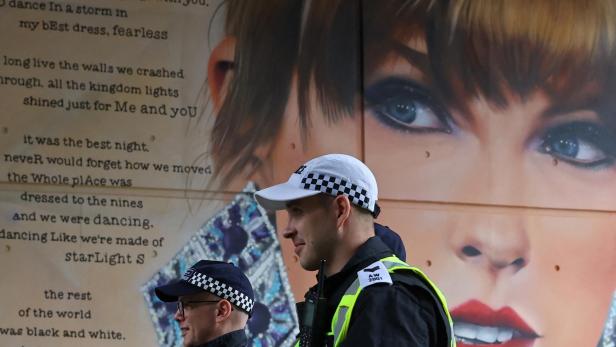 Police officers walk past a mural of Taylor Swift whilst on duty for Community Shield football match, at Wembley Stadium in London