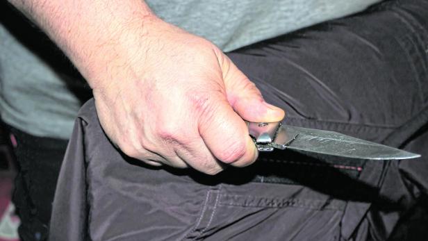 Closeup of a young man hand, holding a knife, about to attack