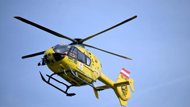 Ein gelber Rettungshubschrauber des ÖAMTC im Flug.