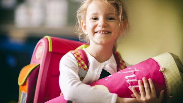 Ein Mädchen hält eine Schultüte in der Hand.