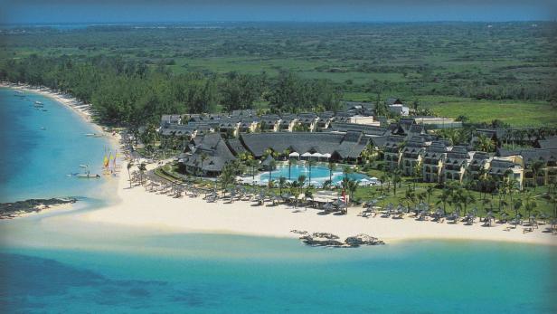 Luftaufnahme eines Resorts mit Pool an einem tropischen Strand.