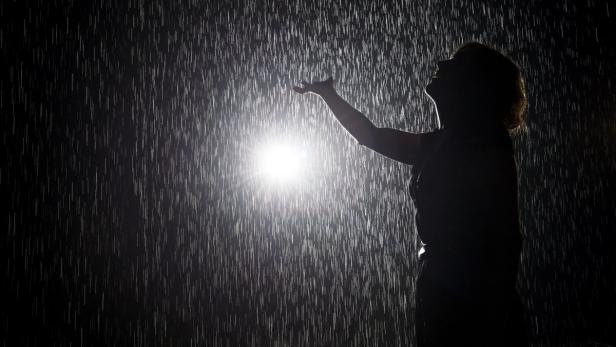 epa03695136 A person walks through the installation &#039;Rain Room&#039;, a large-scale environment by Random International, which is part of EXPO 1: New York, during a preview at the Museum of Modern Art in New York, New York, USA, 10 May 2013. The installation, which runs through 28 July, allows visitors to walk through a field of falling water which pauses wherever a human body is detected. EPA/JUSTIN LANE