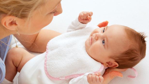 Mother having fun with newborn baby girl