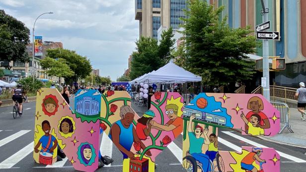 Buntes NYC-Logoschild an den autofreien Summer Streets auf dem Adam Clayton Powell Jr Boulevard in Harlem, New York City