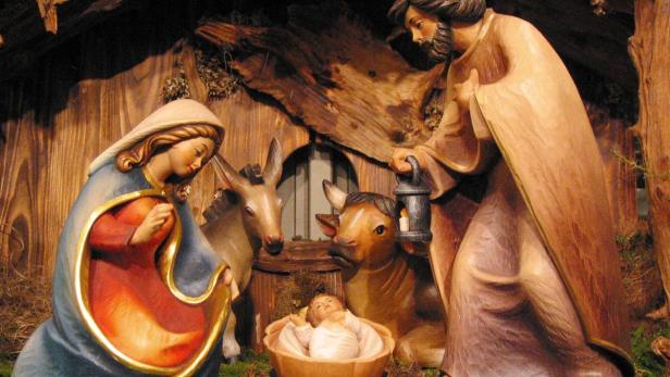 Eine geschnitzte Weihnachtskrippe mit Maria, Josef, dem Jesuskind, einem Ochsen und einem Esel.