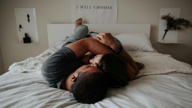Auf TikTok macht zurzeit ein Test die Runde, der zeigen soll, wie zukunftsträchtig die Liebesbeziehung ist.  Ein Paar liegt eng umschlungen auf einem Bett.