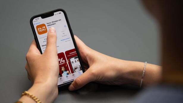 Eine Person installiert die Temu-App auf einem Smartphone.