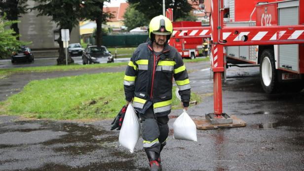 Feuerwehrmann trägt Sandsäcke