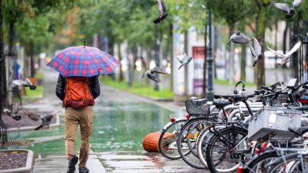 Mann geht mit Regenschirm 