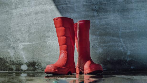 Rote Gummistiefel stehen im Wasser